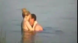 Blondine umklammert nackten Mann leidenschaftlich im See