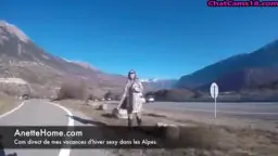 Vollbusige Brünette steht komplett nackt an einer sonnigen Alpenstraße und posiert selbstbewusst für die Kamera