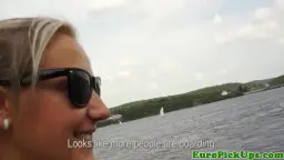 Blonde mit Sonnenbrille am Seeufer, enger Ausschnitt, flacher Hintergrund