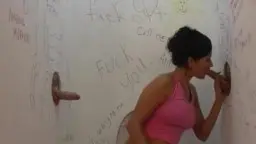 Heiße MILF im pinken Top lutscht zwei Schwänze gleichzeitig in der Gloryhole-Kabine
