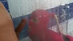 Frau in rotem Latexanzug und Gasmaske steht unter der Dusche