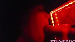 Blonde Frau kniet vor rot beleuchtetem Gloryhole und lutscht riesigen schwarzen Schwanz